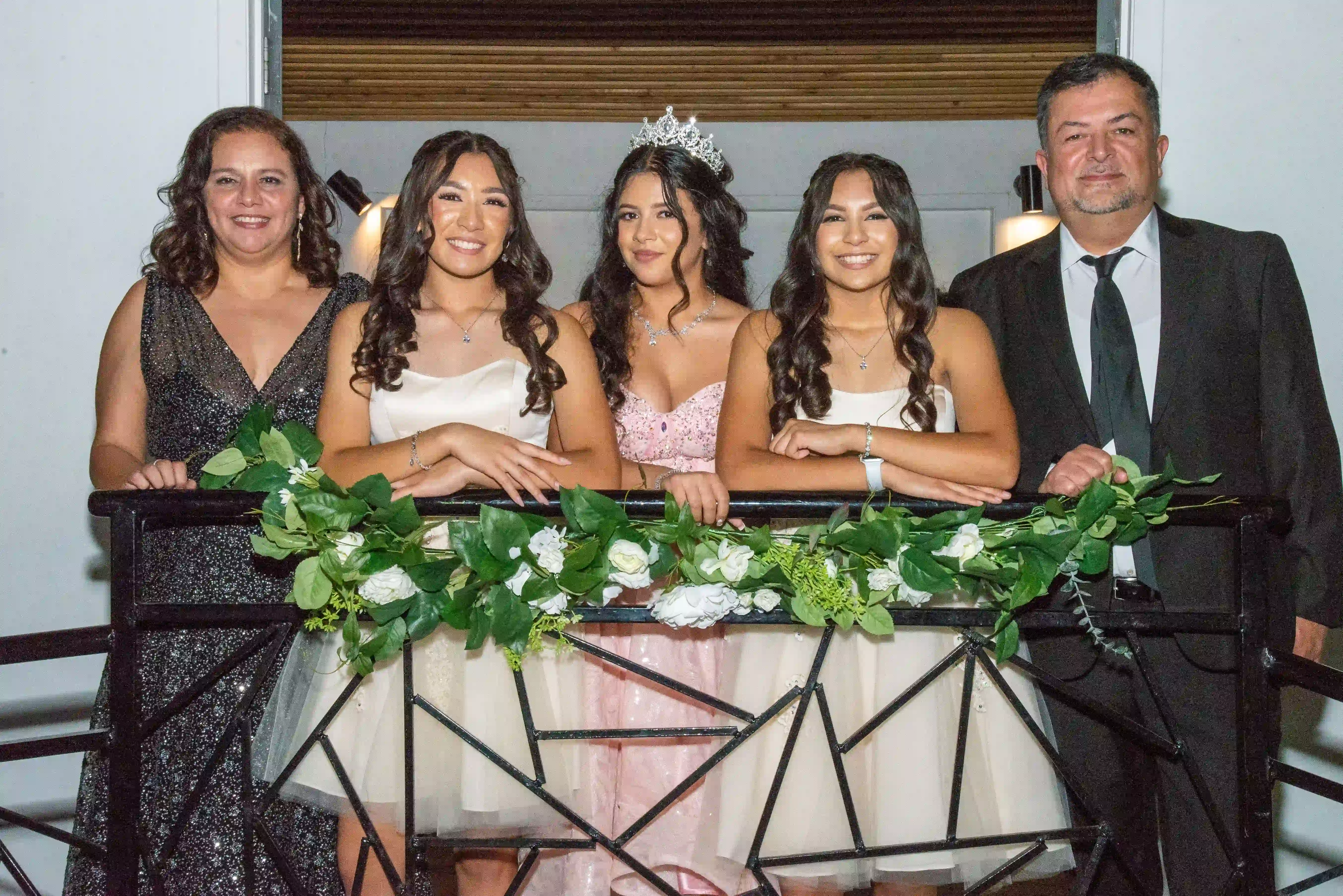 A quinceañera and her family gathered together on the gallery's iron staircase