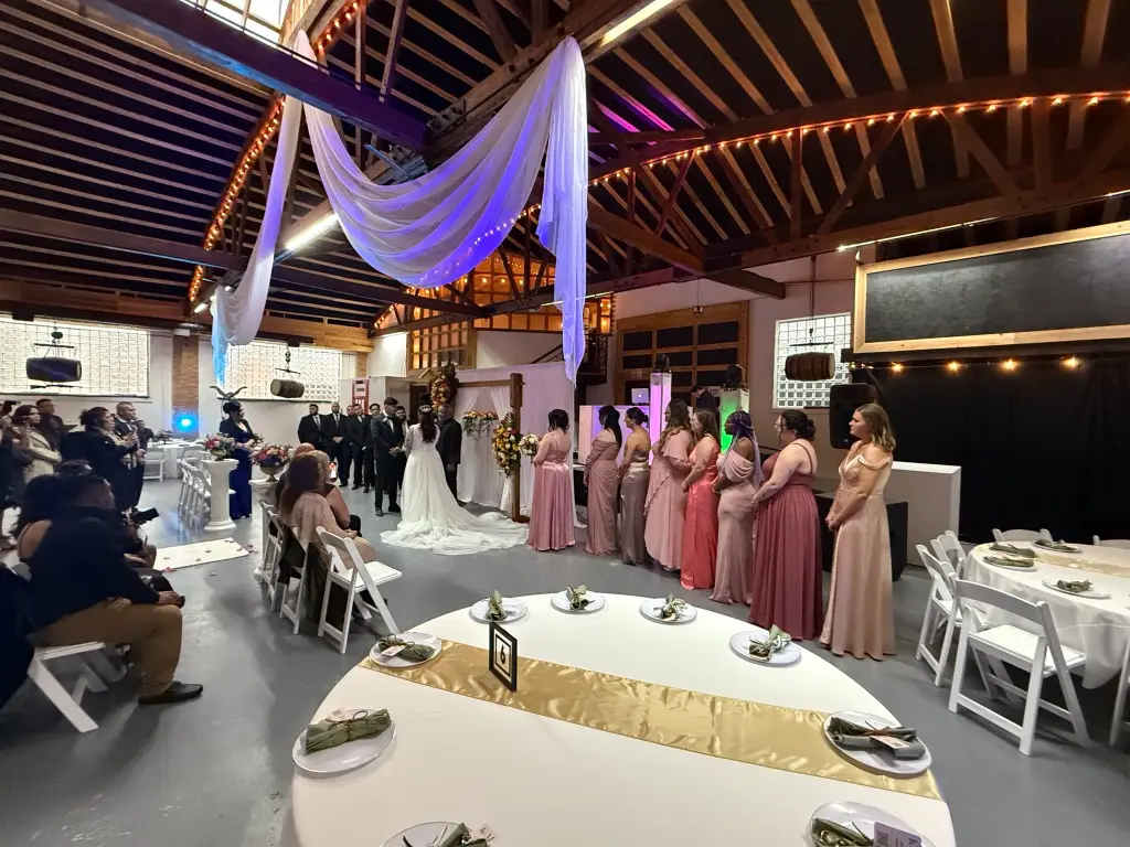 A wedding ceremony underway, the couple at the altar framed by their wedding party
